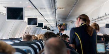Flugzeugkabine mit Passagieren und Stewardess