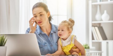 gestresste Frau mit Kind am Laptop
